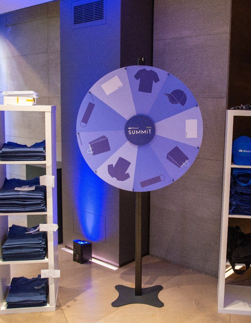 Ruota della fortuna con scaffali di gadget a un evento aziendale